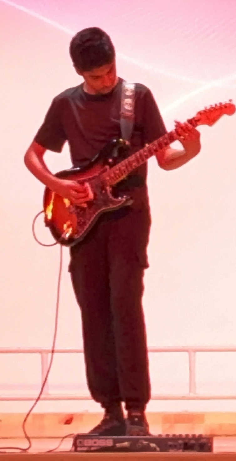 GuitarisGood performing on stage with an electric guitar